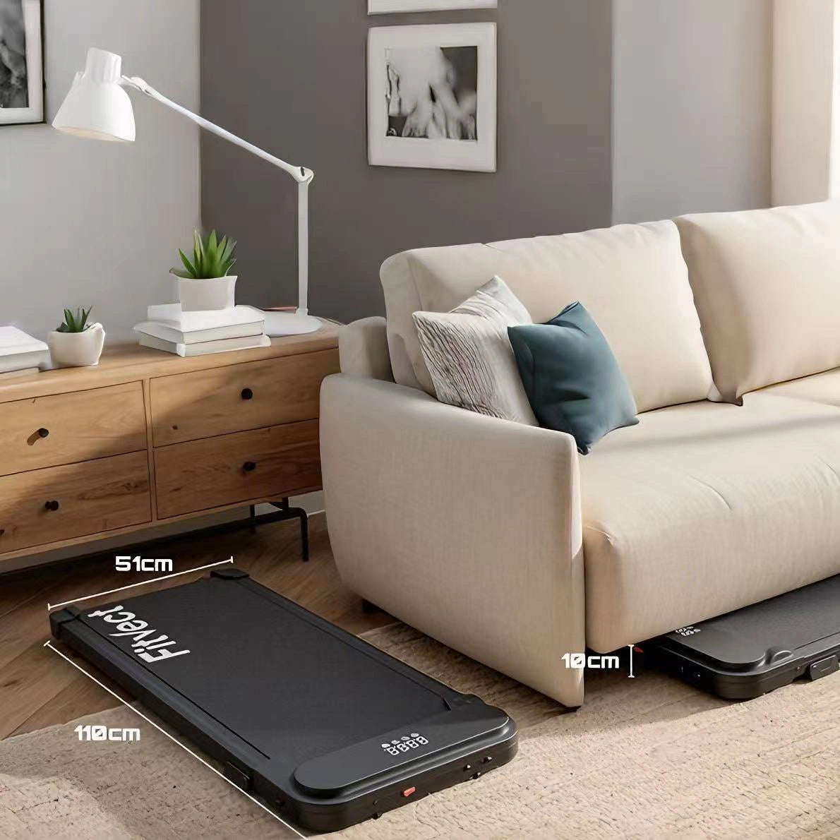 fitvect portable c1 treadmill on a wooden floor next to a beige sofa in a living room setting.